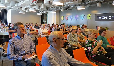 Founding event of tekom Israel in 2017 with Michael Fritz sitting in audience chair with many other attendees in the background