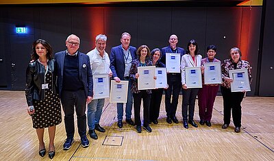 group picture of Michael Fritz and Tiziana Sicilia with volunteers that received certificates of honor in Stuttgart in 2023